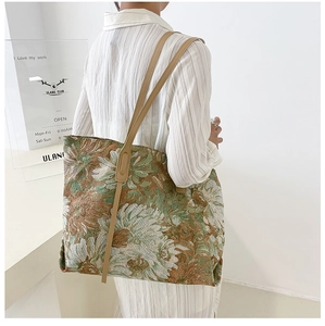 Detail of vintage floral jacquard tote bag with leather straps on a model