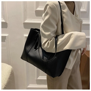 Classic black oversized faux leather tote bag with lychee texture shown on a model