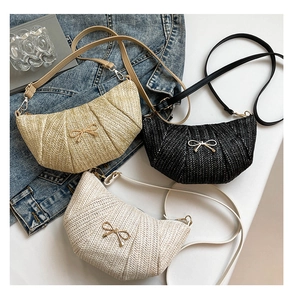 Detail of woven crescent crossbody bags with metal bow accent in khaki, black, and white