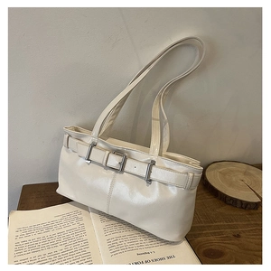 Macro shot of white leather underarm bag featuring metal buckle and textured PU finish