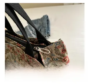 Close-up of the smooth metal zipper and floral canvas fabric on this tote bag