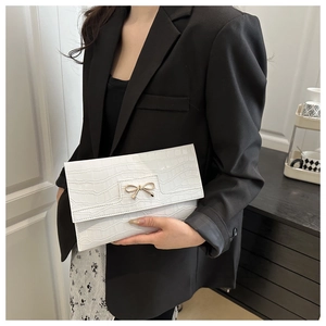 Detail of white stone pattern PU clutch featuring a gold bow-knot metal clasp and texture