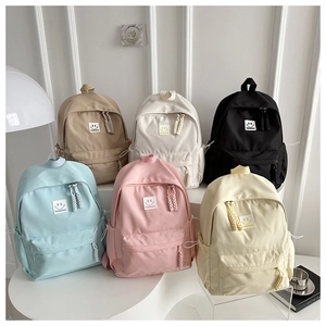Detailed view of casual nylon backpacks in six solid colors with smiley face patch