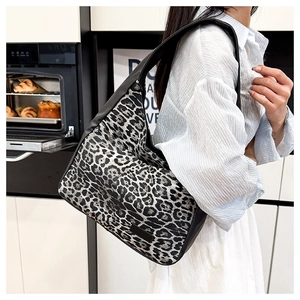 Detail of leopard print shoulder bag with black leather strap and logo plaque