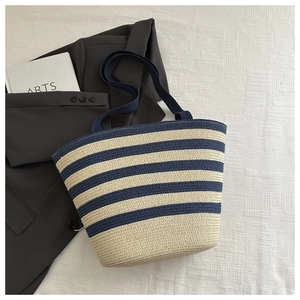 Top view of striped raffia tote bag with navy blue and cream woven texture details