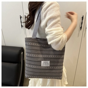Détail de la texture rayée tissée et de l'étiquette mode sur le grand sac cabas décontracté