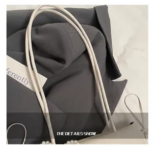 Detail showing high-quality white PU leather handle and elegant pearl trim on a shoulder bag