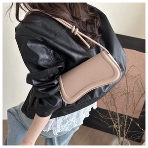 Detail of light beige leather shoulder bag featuring knotted strap and gold logo embossing