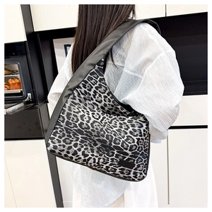 Detail shot of the large leopard print hobo bag showing the wide black shoulder strap and texture