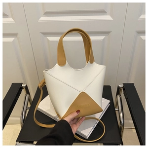 Vue détaillée d'un sac seau bicolore blanc et jaune en similicuir sur une chaise.
