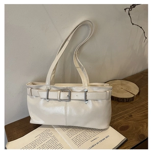 Close-up of retro cream underarm bag featuring adjustable buckle and glossy faux leather