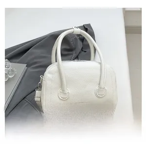 Détail du sac blanc en cuir à grain litchi avec texte de mode et double poignées