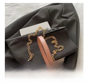 Detail showing pink textured leather handbag with gold chain strap and MK pattern
