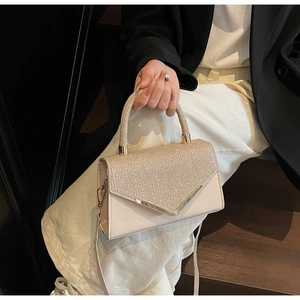 Detail van de elegante champagne strass handtas met goudkleurige V-vormige bies.