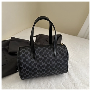 Dettaglio della chiusura a zip e dei manici in pelle sulla borsa tote con stampa vintage