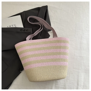 Detailed view of pink and beige striped straw tote bag with wide fabric handles