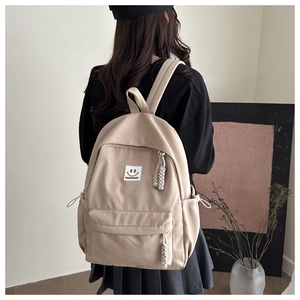 Modern beige waterproof nylon backpack with multi-pocket design on female model