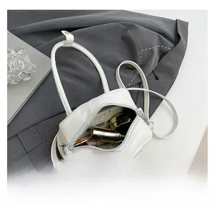 Gros plan sur la capacité intérieure du mini sac à main blanc en cuir grainé