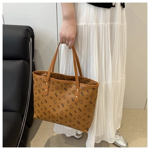 Detailed close-up of textured leather tote bag featuring cute cartoon bear print