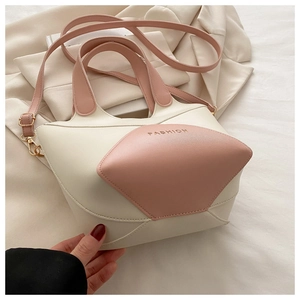 Gros plan sur le sac seau en similicuir bicolore rose et crème montrant le grain