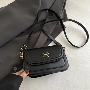 Sac bandoulière noir élégant avec détail nœud doré et bandoulière réglable