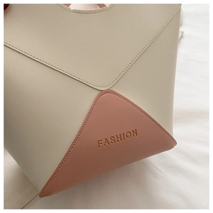 Gros plan détaillé d'un sac seau en cuir PU bicolore avec lettrage FASHION embossé