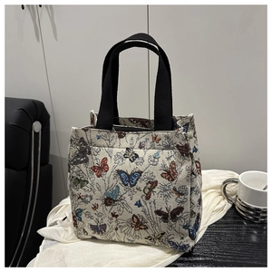 Detail of vintage canvas tote with colorful butterfly embroidery and black straps