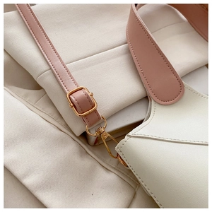 Vue détaillée d'un sac seau chic en PU crème et rose avec une boucle dorée élégante.