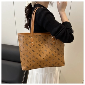Detail of large brown tote bag featuring printed cartoon bears and repetitive motifs