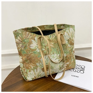 Detail of vintage floral jacquard fabric and beige handles on a large tote bag