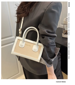 Model wearing a white leather and woven crossbody bag with Ambler 1986 logo details