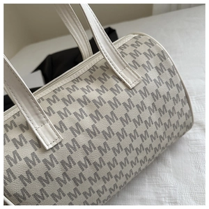 Dettaglio borsa a bauletto in pelle bianco crema con stampa monogramma M grigia