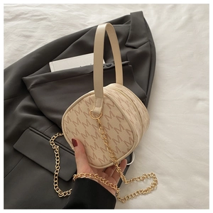 Close-up of a beige PU leather mini bag with M-logo print and a gold chain strap