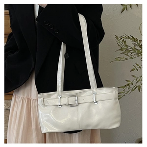 Detail of white leather underarm bag with silver buckle strap shown on a model