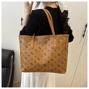 Detail of a brown tote bag with bear pattern and gold rivets shown from a side perspective