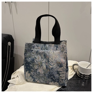 Detail of vintage floral jacquard fabric with blue-white pattern and black handles