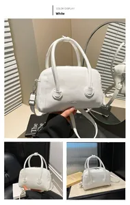 Detailed view of white litchi grain leather texture and metallic hardware on handbag