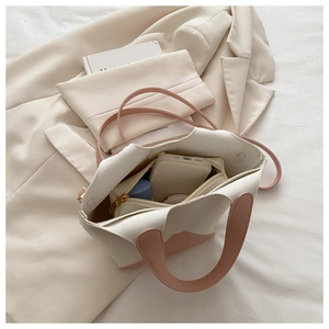 Vue intérieure du sac seau beige et rose montrant sa capacité pour téléphone et accessoires