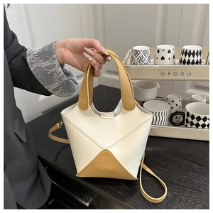 Sac seau vintage bicolore pour femmes, vue portée main avec bandoulière amovible.