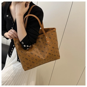 Détail d'un sac cabas marron avec motifs d'ours et texture en cuir fin