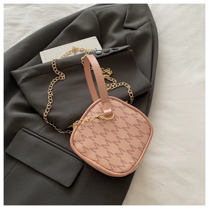 Detailed view of pink crossbody bag with M-pattern jacquard and gold chain strap