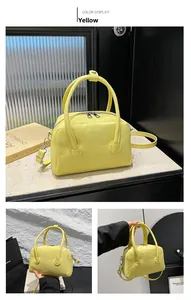 Detail of yellow lychee grain leather handbag with dual zippers and silver hardware