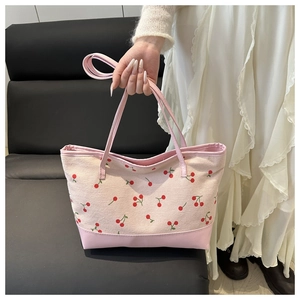 Détail du sac cabas rose avec motifs de cerises et finitions en tissu rose