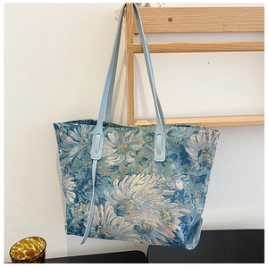 Detail of blue floral tapestry tote bag with light blue faux leather shoulder straps
