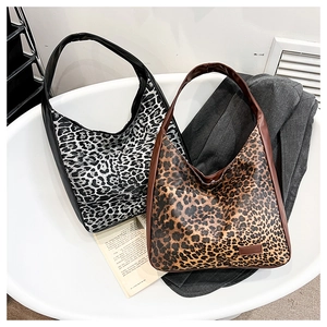 Détail de sacs cabas à imprimé léopard en noir et marron avec bordures en similicuir