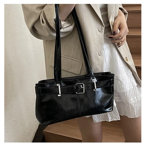 Detail of glossy black underarm bag with silver buckle and double thin shoulder straps