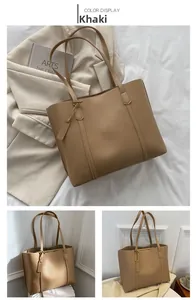 Detail of khaki leather tote bag with vertical stitching and matching hanging tag