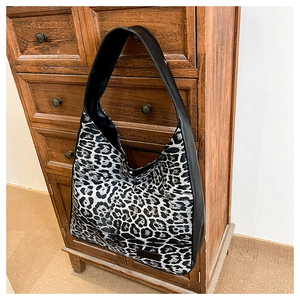 Détail d'un sac hobo avec imprimé léopard noir et blanc et bandoulière noire robuste