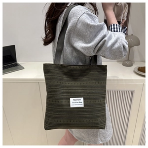 Détail d'un sac cabas en maille vert olive avec texture tissée et étiquette tendance