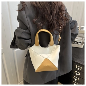 Sac seau moderne en PU patchwork crème et jaune stylisé avec un blazer gris pour un look chic.